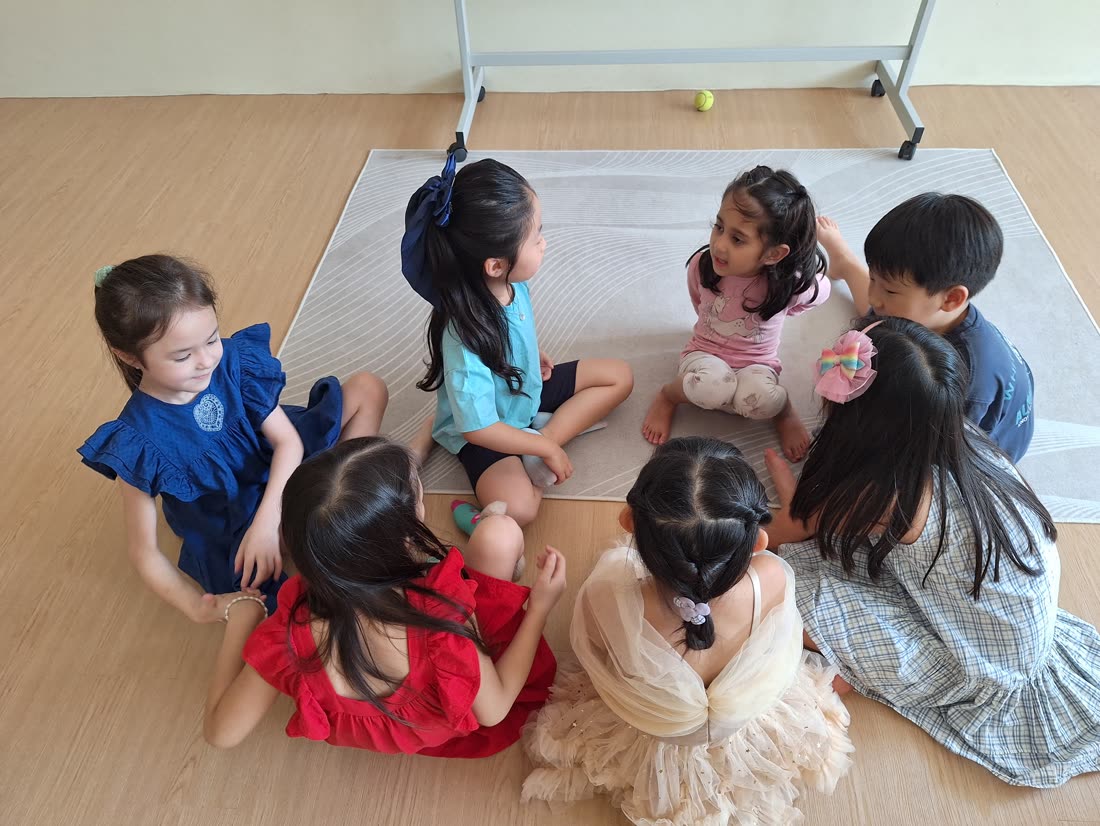 Kids sitting in a circle during a drama warm-up game