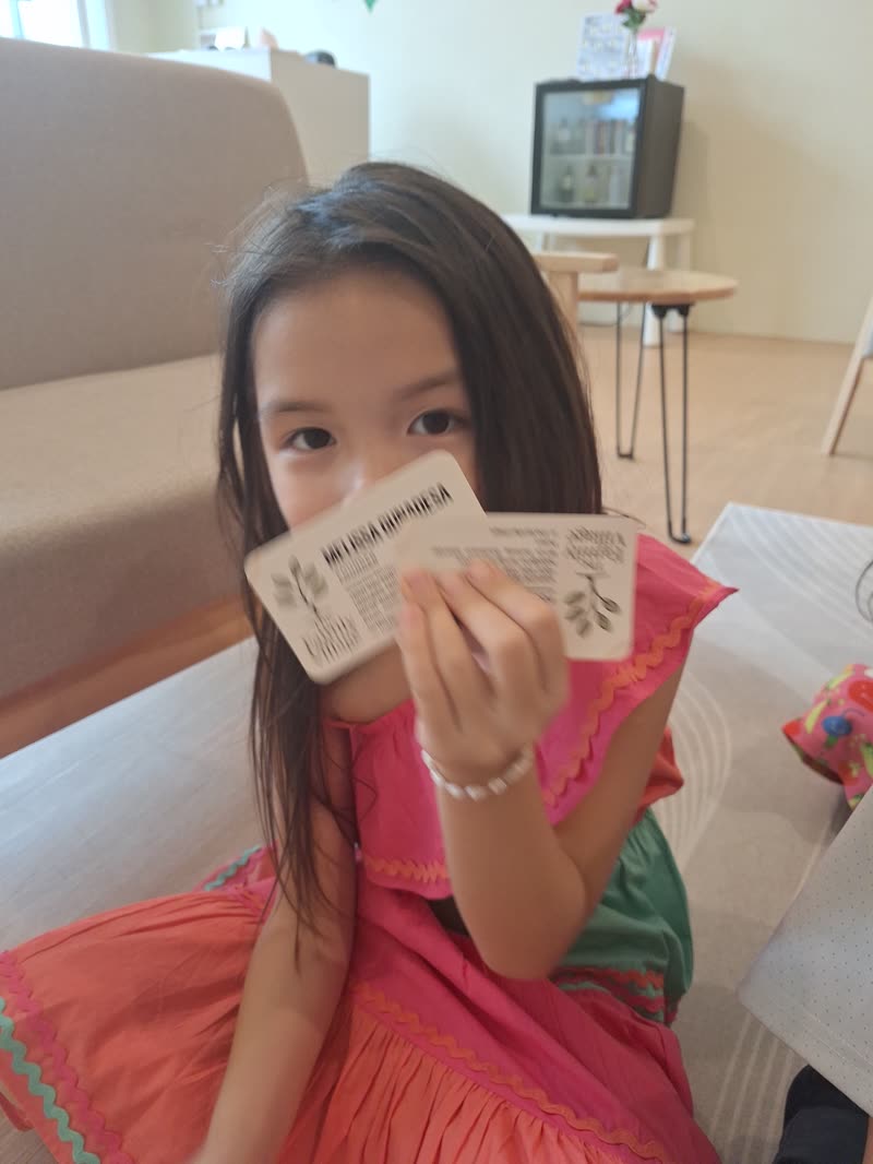 A girl proudly holding up her speech cards