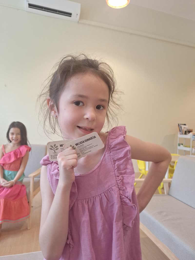 A girl proudly showing her speech card